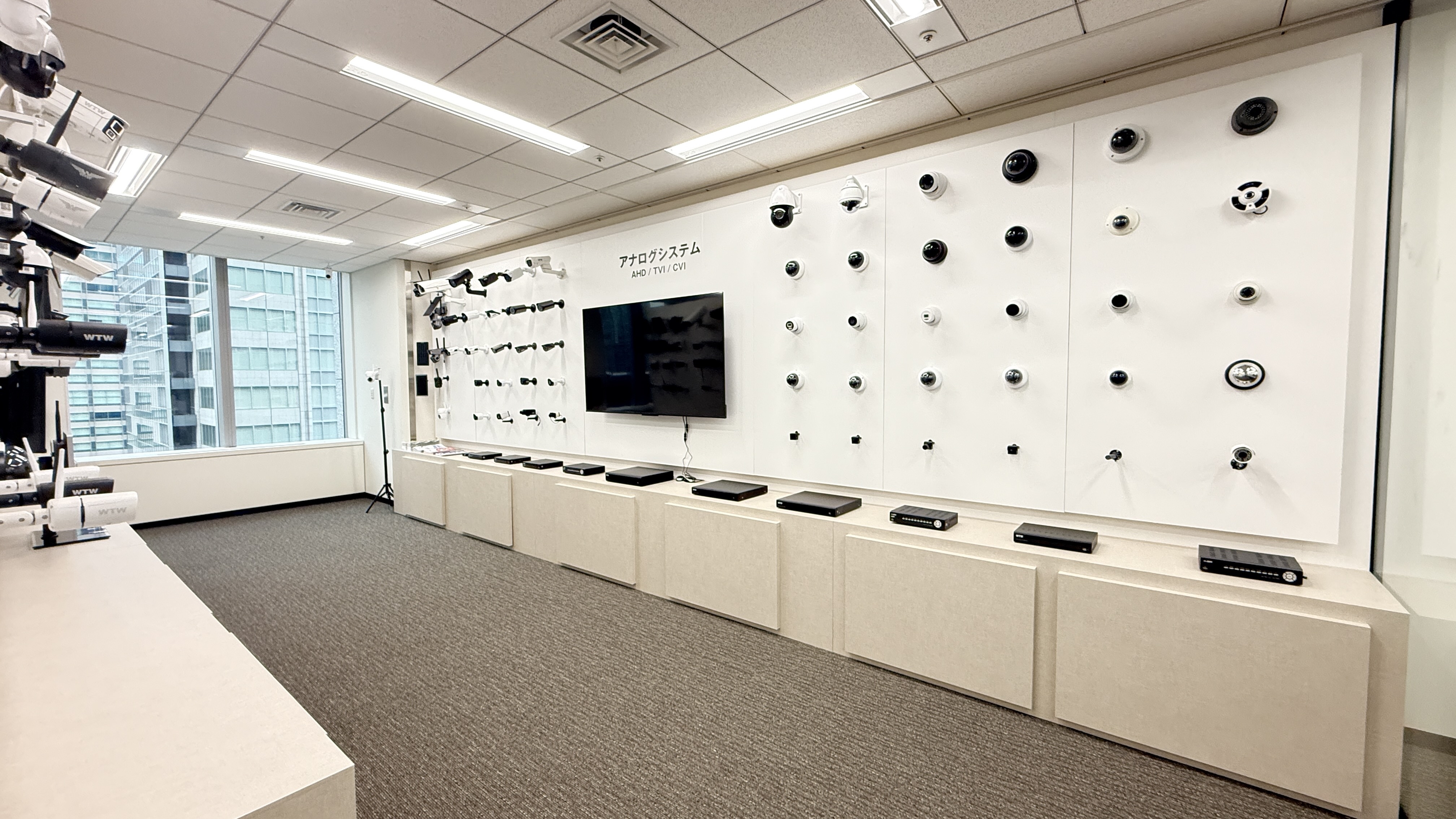 東京支社の展示ルーム。壁面に多数の防犯カメラとレコーダーが整然と展示されている